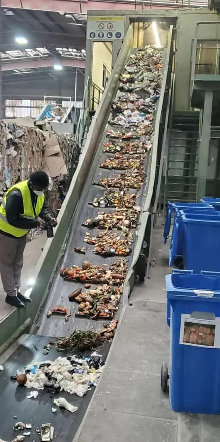 A CRAB engineer inspecting material on a recycling conveyor belt